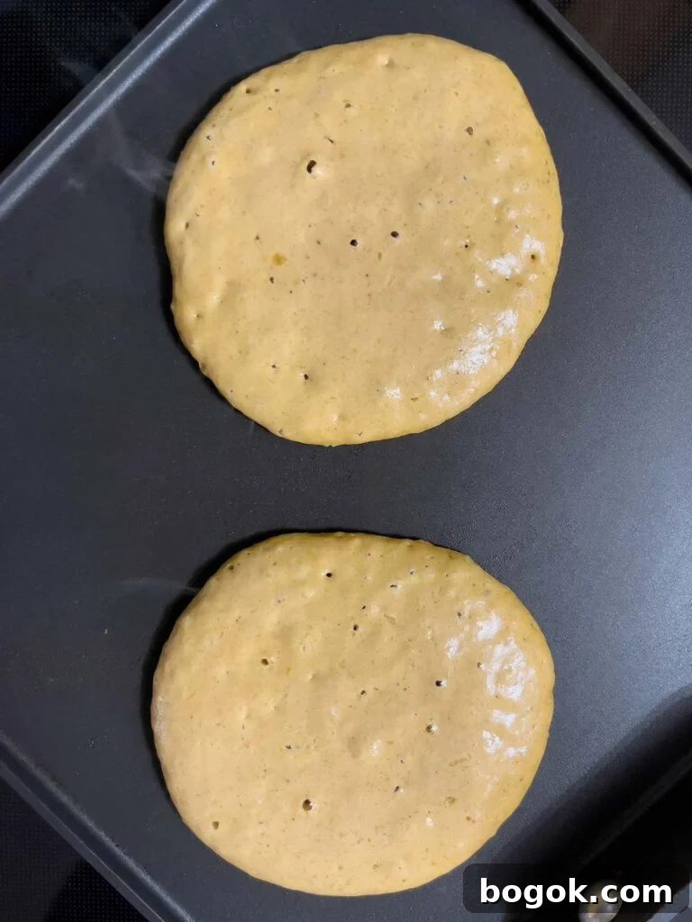 Bubbles popping on pumpkin pancake before flipping.
