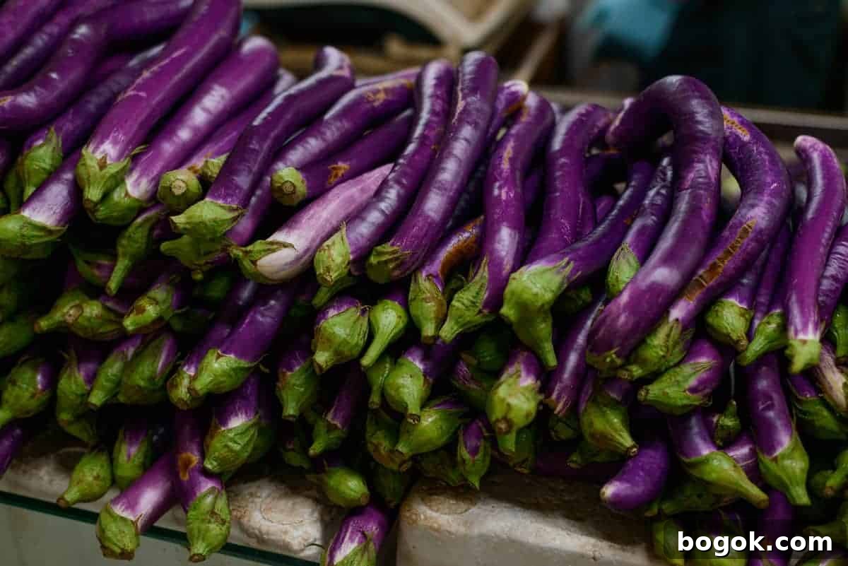 A selection of long and thin Chinese eggplants in a market