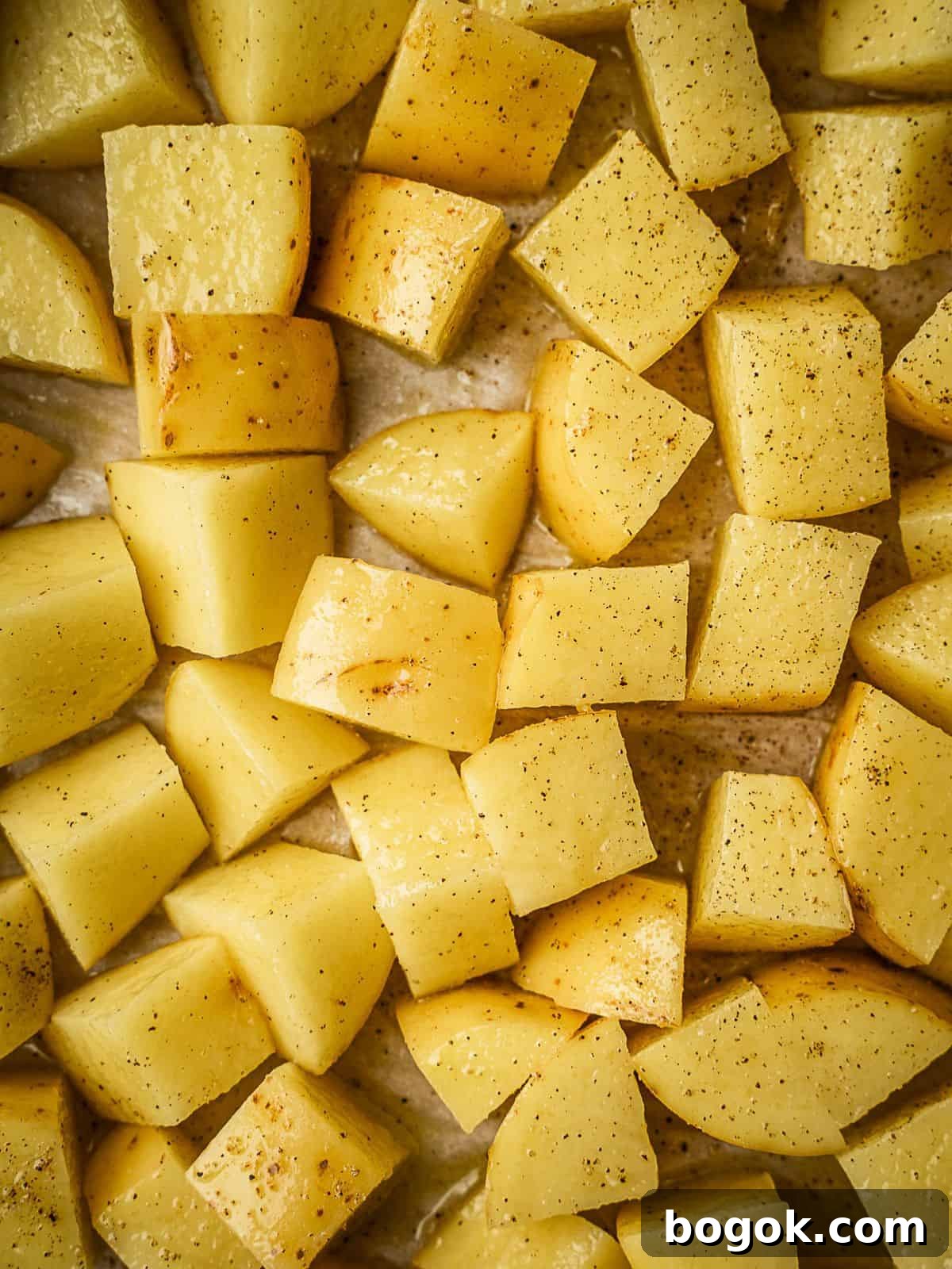Cubed potatoes on a baking sheet.
