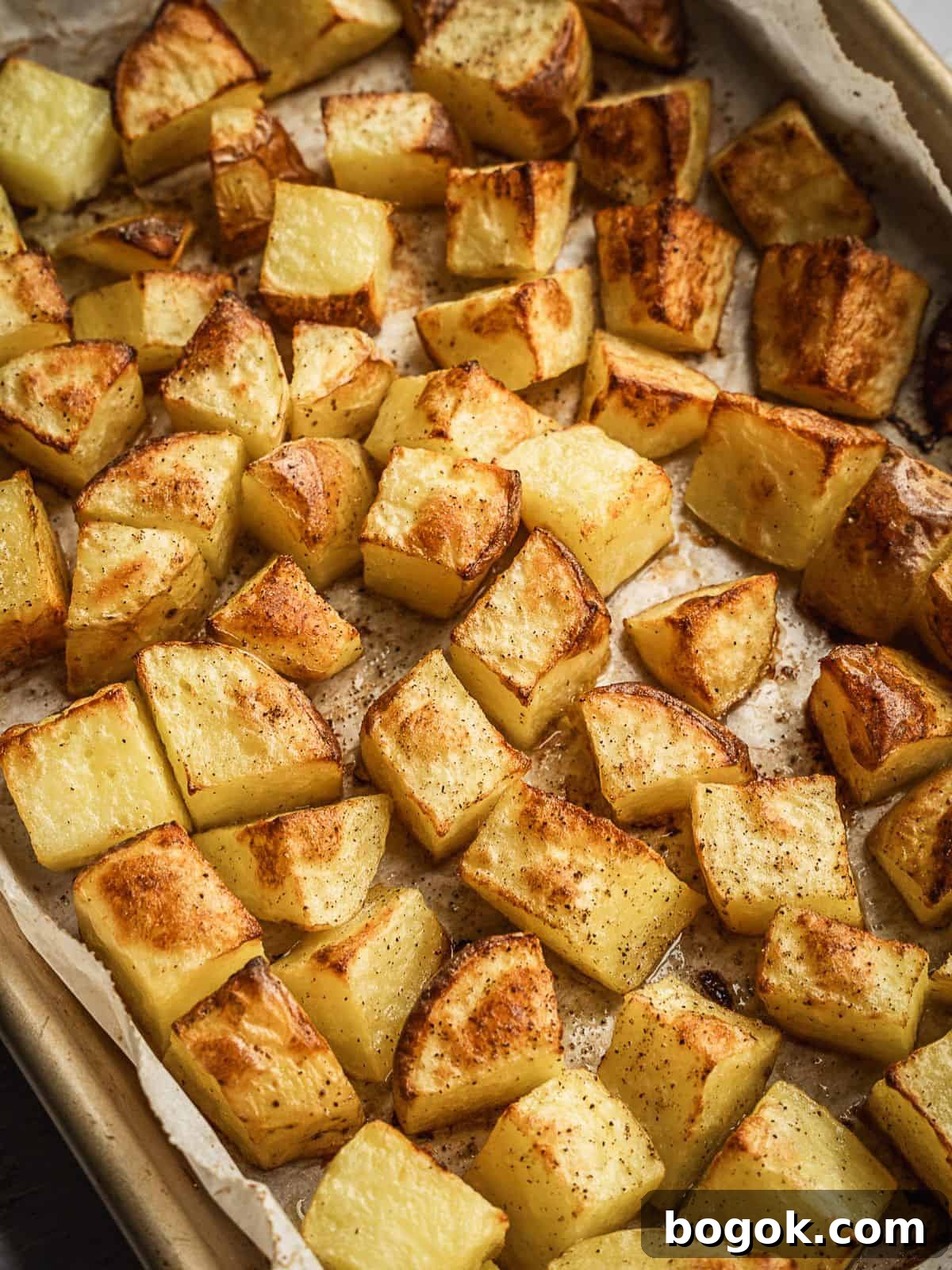 Baked potato cubes on a baking sheet.