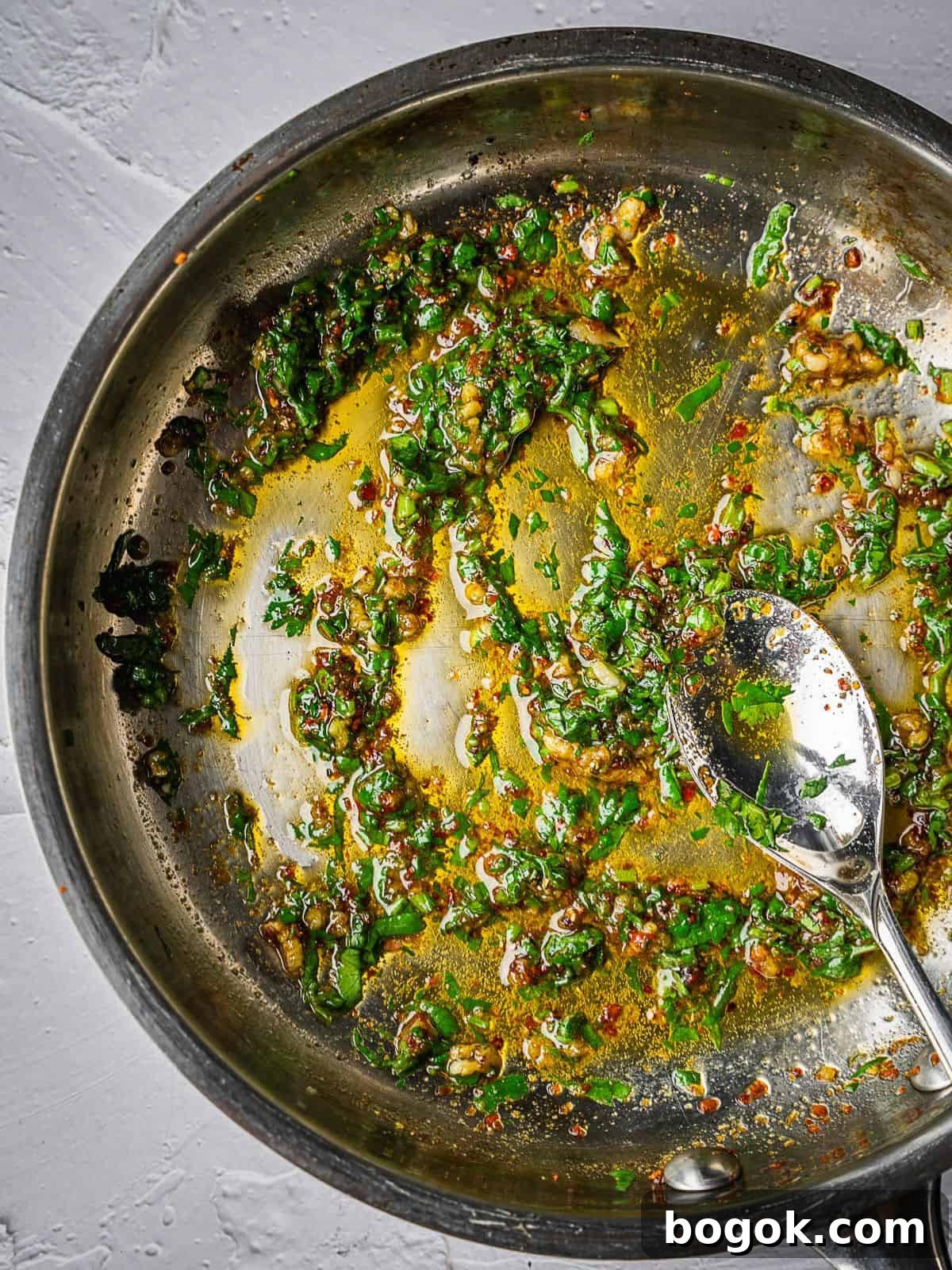 Frying pan with olive oil, spices and cilantro.