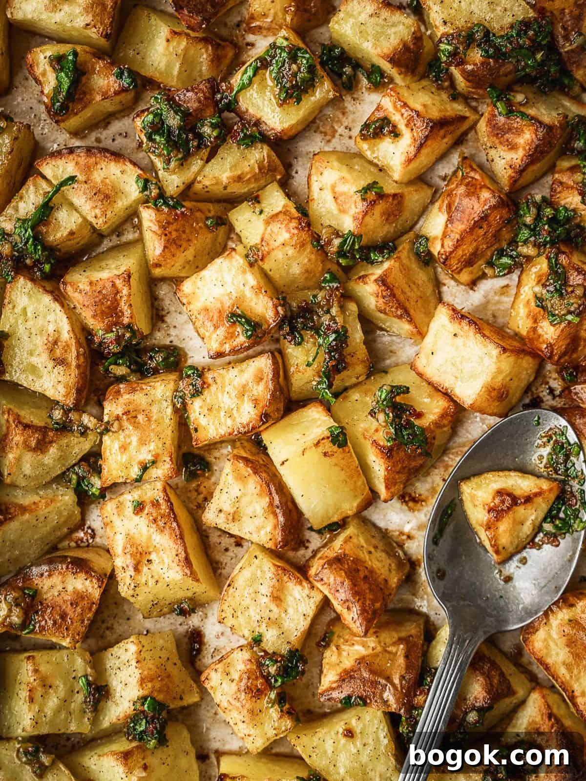 Finished batata harra tray showing the baked potato cubes drizzled with the dressing.