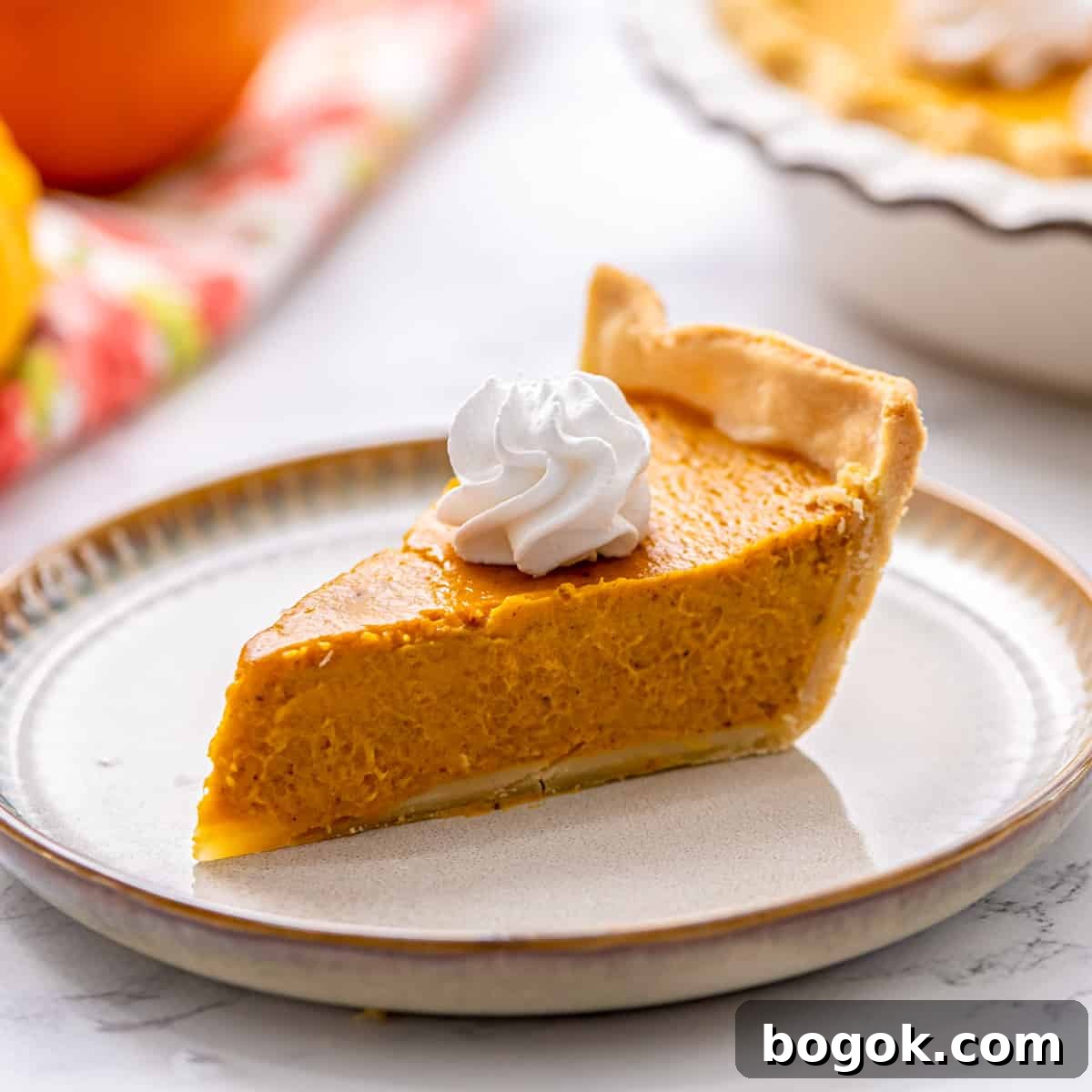 Easy Thanksgiving Recipes Slice of pumpkin pie on plate toped with whipped cream.