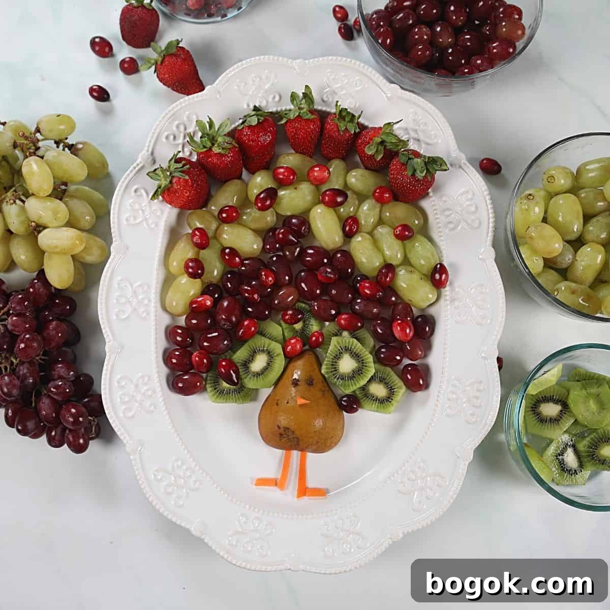 simple Thanksgiving recipes Fruit arranged to look like feathers of a turkey on a white platter.