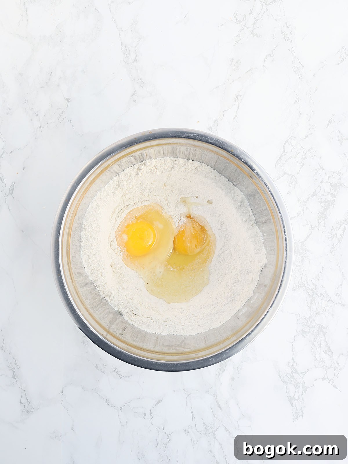 Classic Southern Skillet Cornbread Recipe for Crispy Golden Crust 8 Cornmeal with two large eggs in a metal mixing bowl.