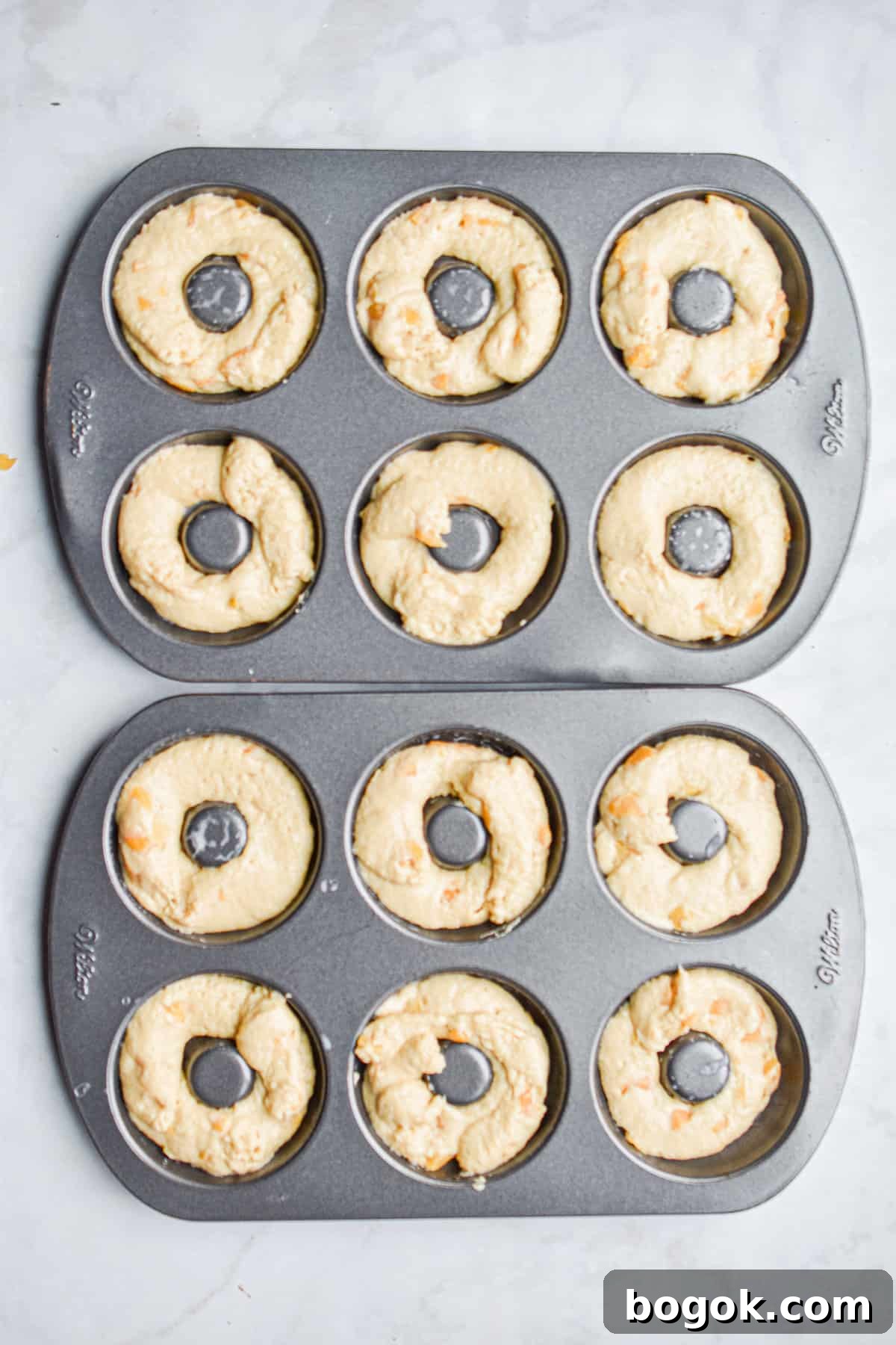 Baked Dairy-Free Peach Donuts Recipe 9 The batter is added to the donut tray and ready to be baked.