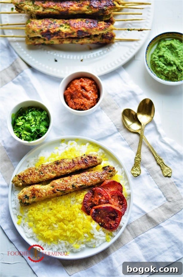 Authentic Chicken Seekh Kebab Recipe: Juicy Grilled Skewers 10 Chicken seekh kabab on a plate with rice, tomatoes & chutneys