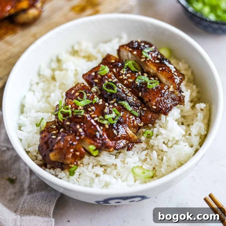 Teriyaki chicken rice bowl (donburi) made with homemade teriyaki sauce and served with chopsticks.