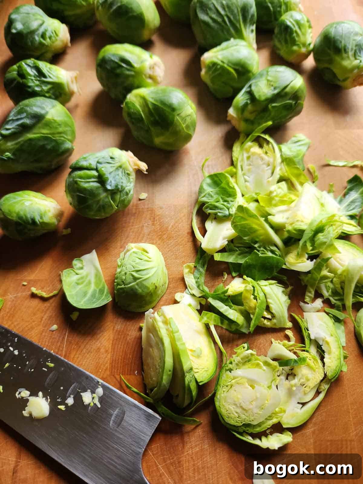 Crispy Brussels Sprout Hash with Bacon and Caramelized Onions 4 Brussel sprouts on a cutting board with a knife to the left.