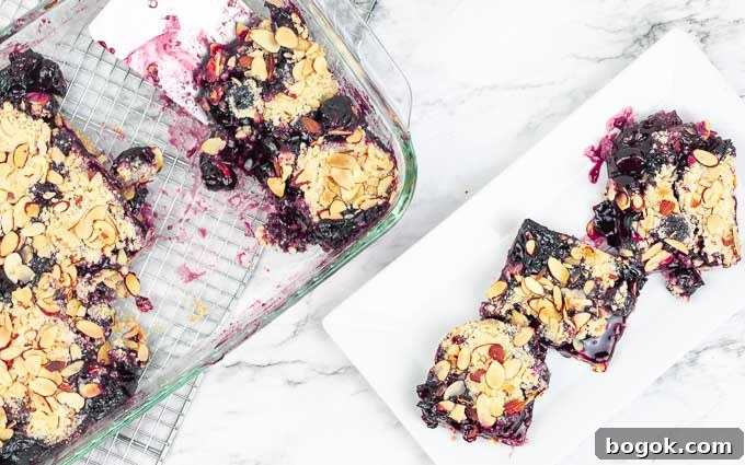 cherry almond pie bars being sliced and on a plate