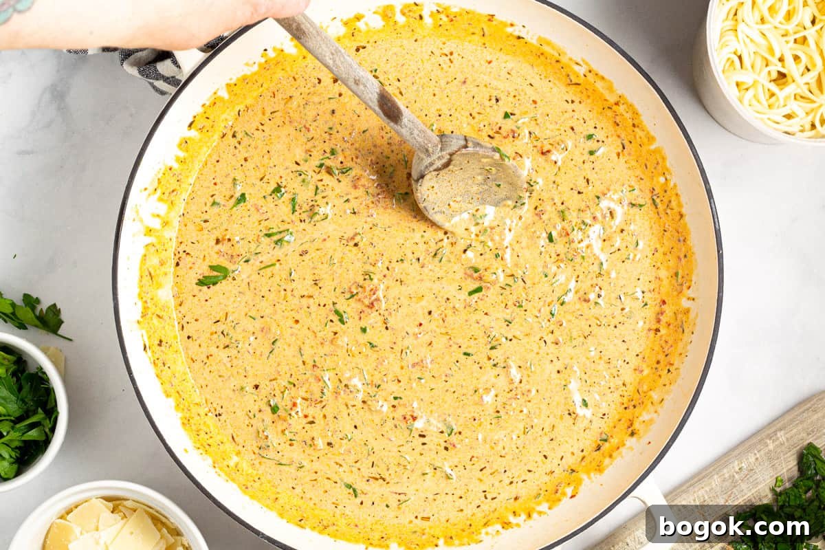 15-Minute Cream Tomato Pasta with Garlic and Basil 8 A large pan filled with creamy sun dried tomato sauce.