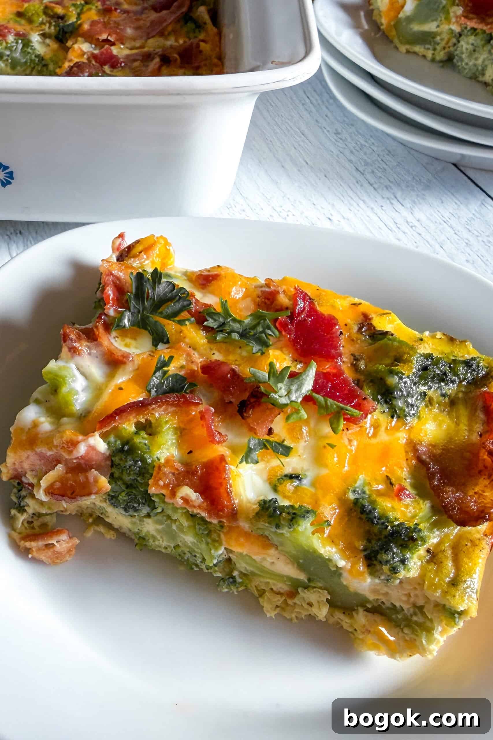 Low-Carb Bacon and Broccoli Breakfast Casserole 3 Close-up slice of low carb bacon broccoli breakfast casserole showing fluffy eggs, broccoli, bacon, and cheddar cheese.