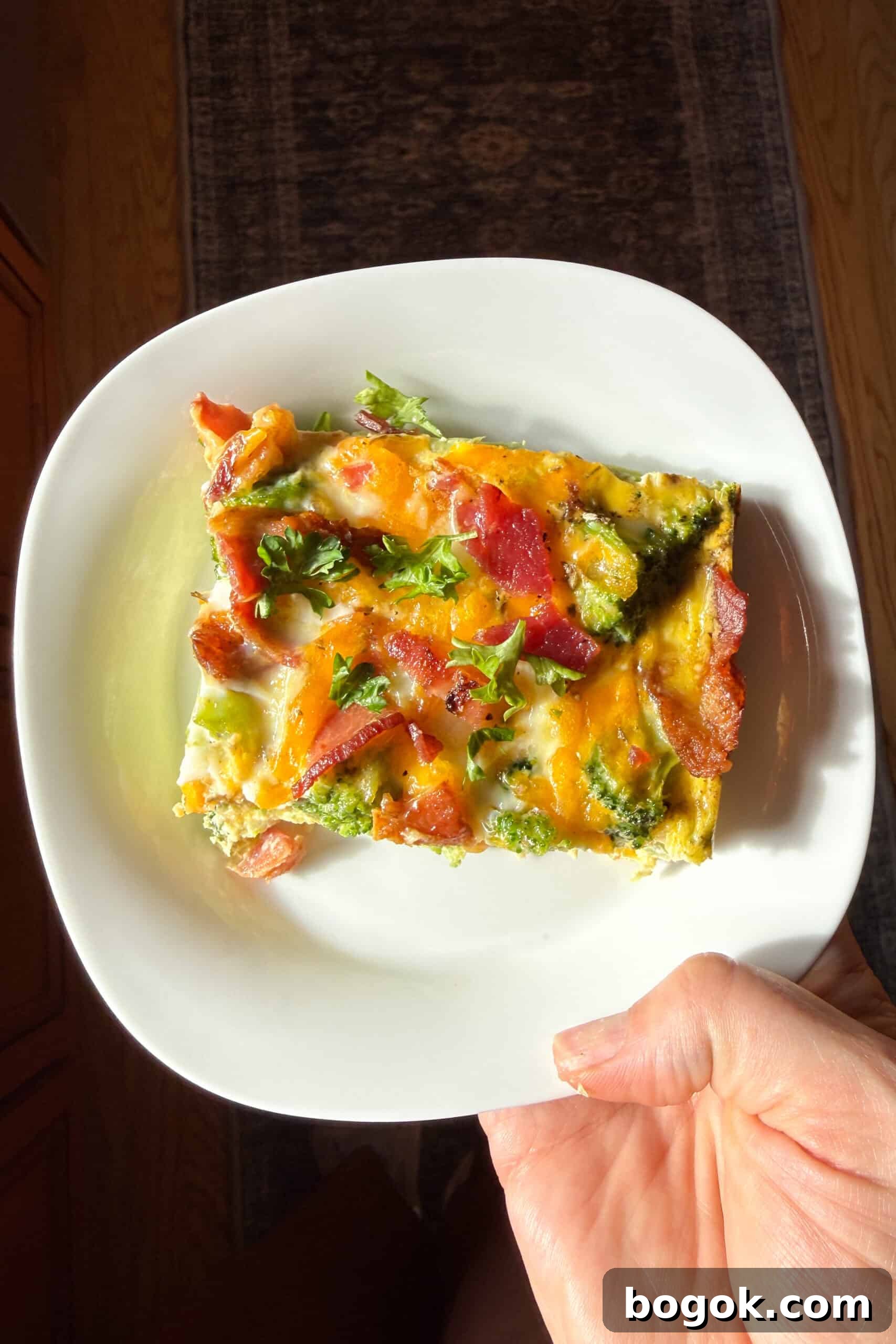 Low-Carb Bacon and Broccoli Breakfast Casserole 9 A slice of bacon broccoli breakfast casserole on a plate.