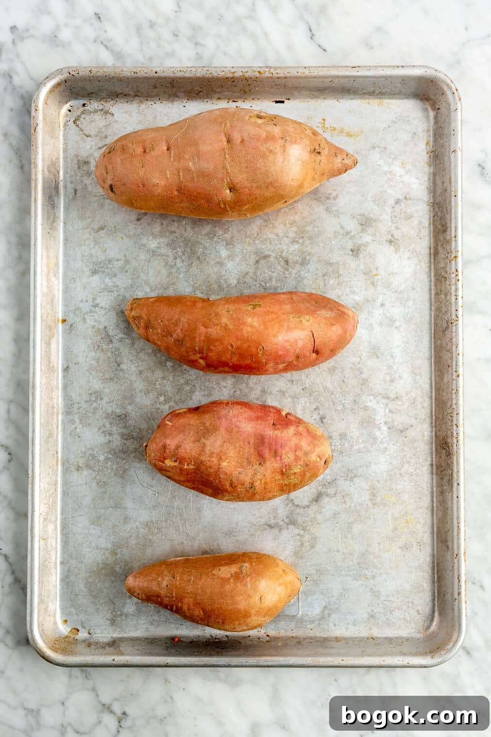 BBQ Chicken and Sweet Potato Casserole Recipe 4 4 sweet potatoes on a sheet pan.