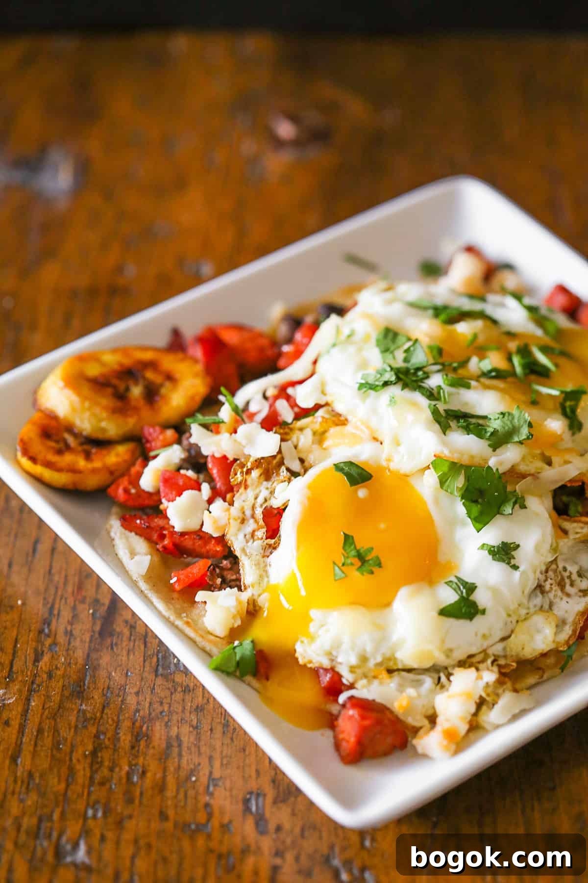 Huevos Motuleños topped with a runny egg. 