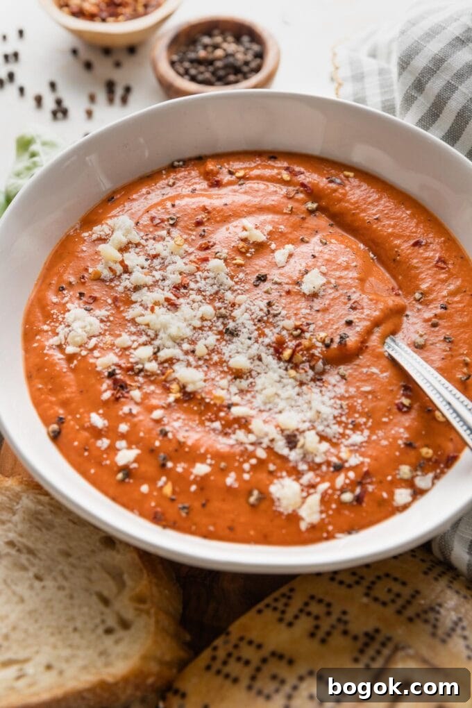Angled view of a bowl of creamy tomato butternut soup.