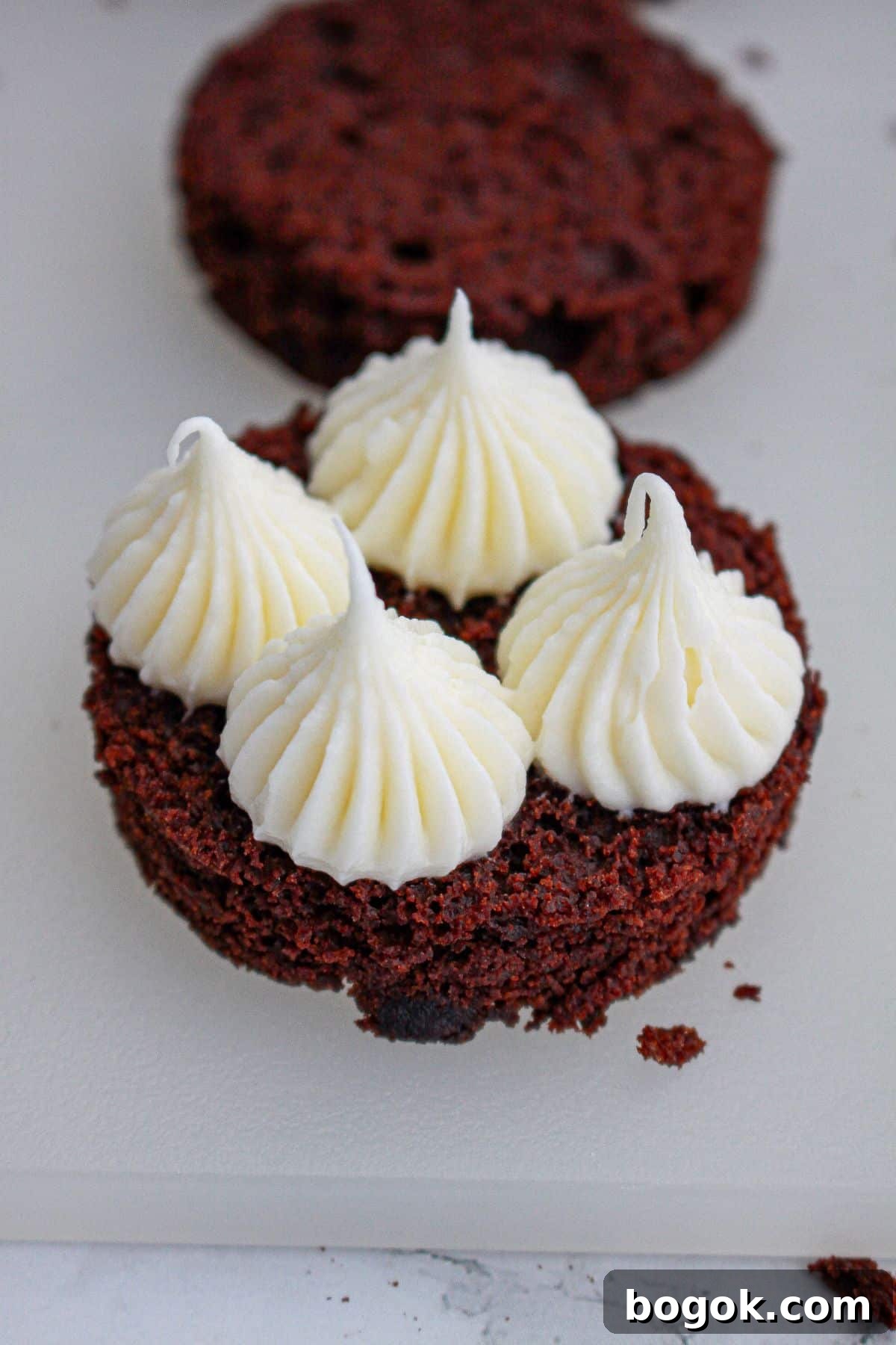 cream cheese icing being piped on a top of a round.