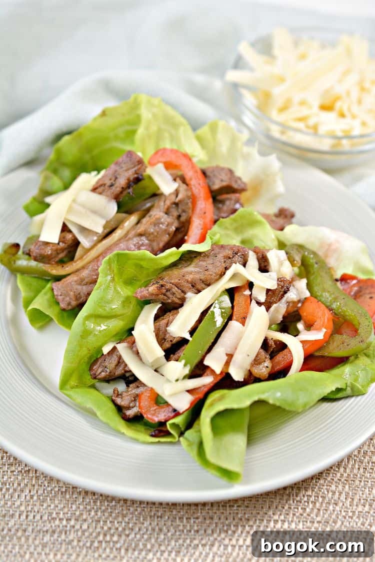 Philly Cheesesteak Keto Lettuce Wraps — Low-Carb Dinner Option 13 two keto lettuce wraps sitting on a white plate on a countertop
