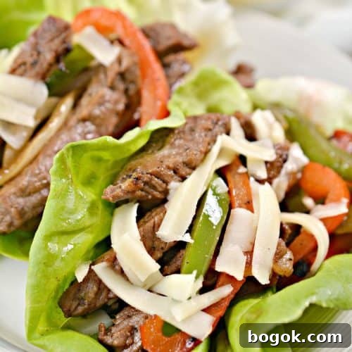 Philly Cheesesteak Keto Lettuce Wraps — Low-Carb Dinner Option 20 closeup of keto lettuce wraps on a white plate with shredded cheese on top