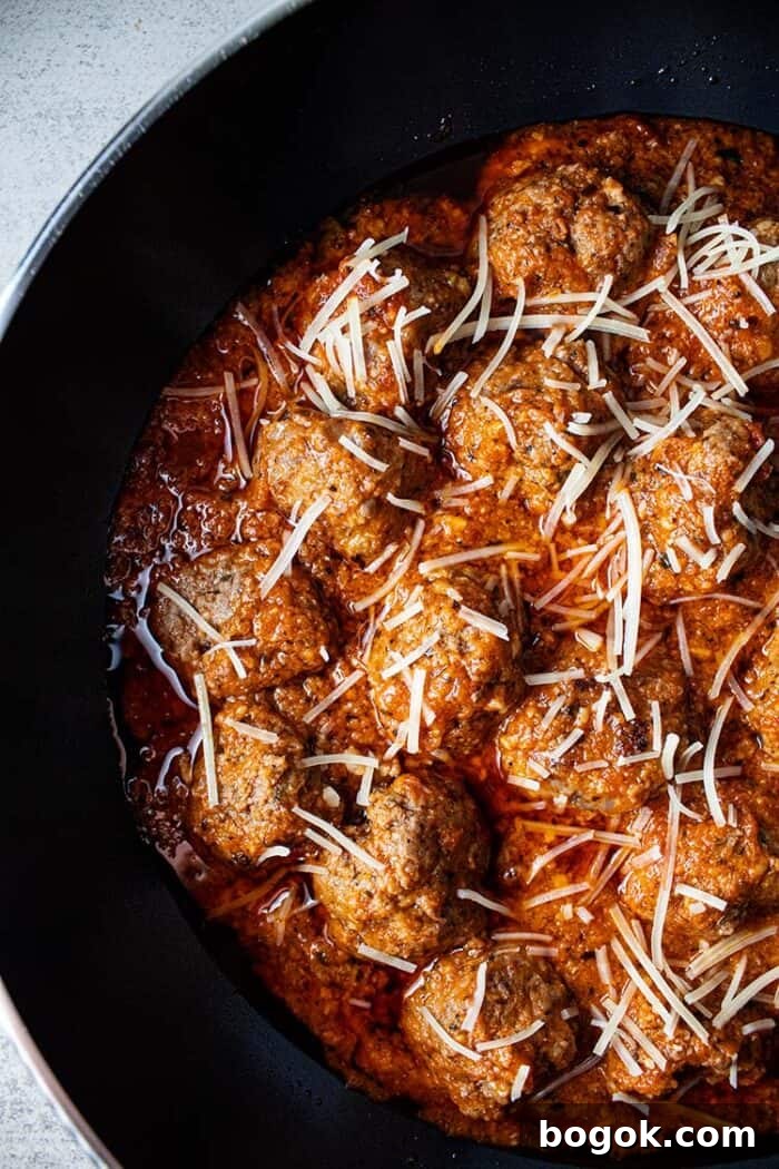Philly Cheesesteak Keto Lettuce Wraps — Low-Carb Dinner Option 10 overhead view of keto meatballs with marinara sauce topped with shredded parmesan cheese in a black skillet