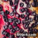 Roasted Cherries in 15 Minutes: Sweet, Syrupy Recipe 11 roasted cherries, just out of the oven, on a gold baking sheet, overhead shot.