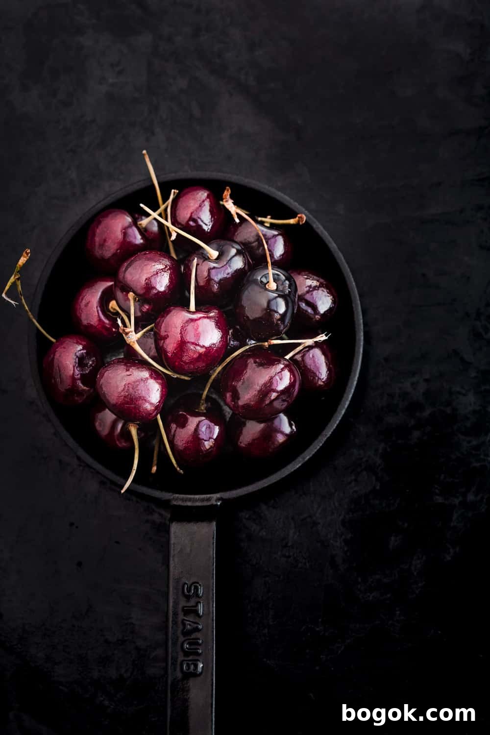 Roasted Cherries in 15 Minutes: Sweet, Syrupy Recipe 9 Whole cherries, with their stems, on a little cast iron skillet.