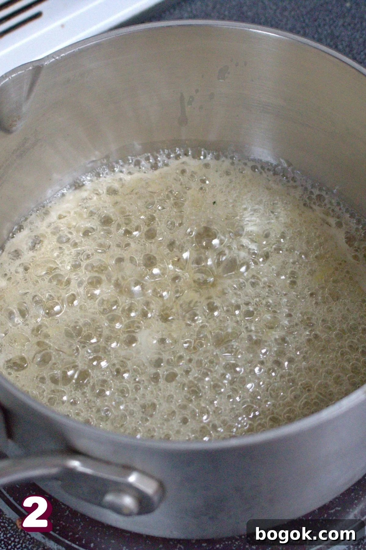 Honey boiling in a small pot on the stove.