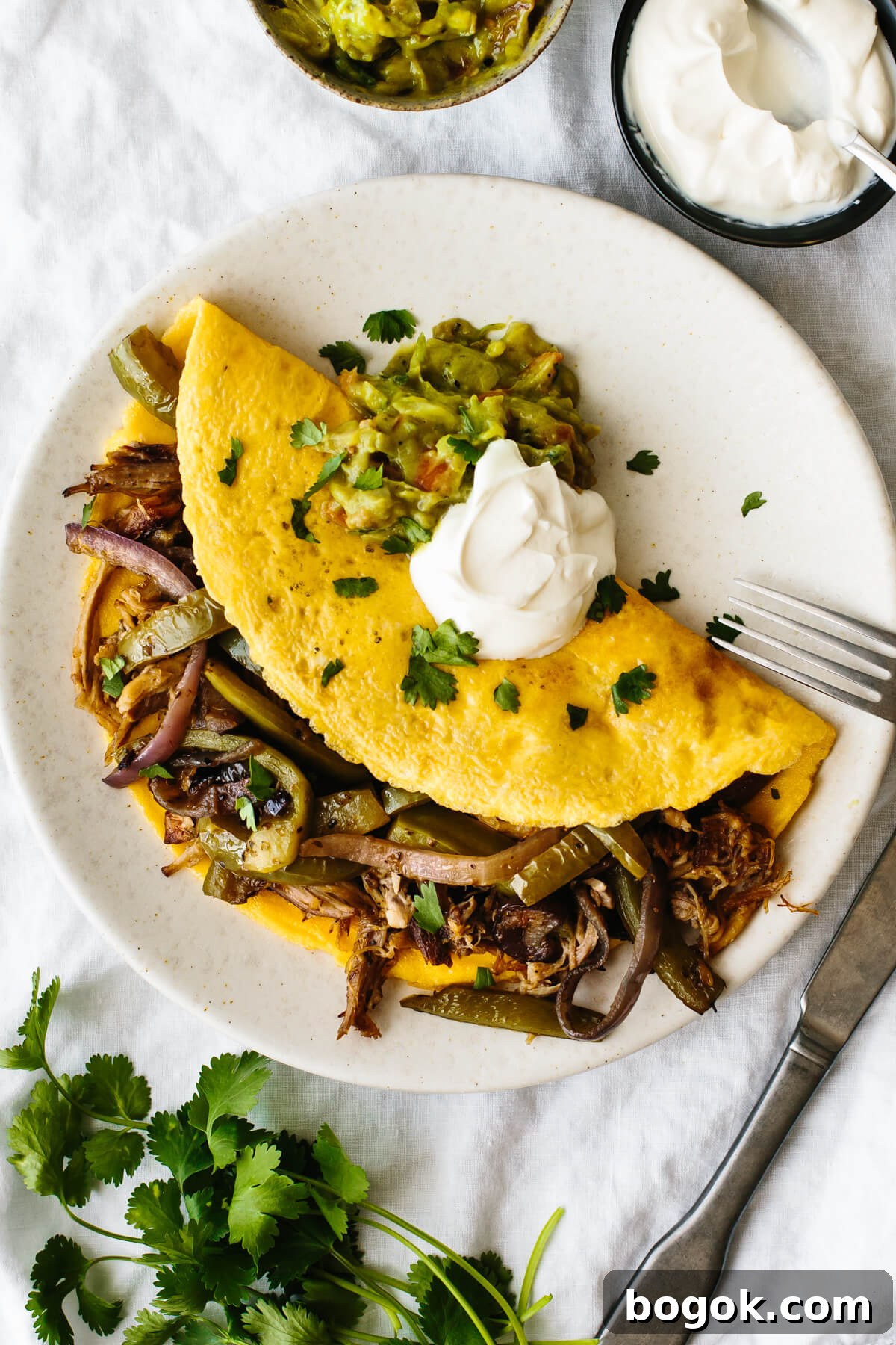 Carnitas omelette with fajita veggies on a plate.