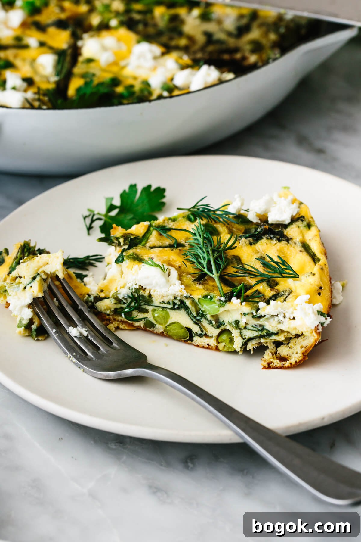 A slice of spring vegetable frittata on a plate