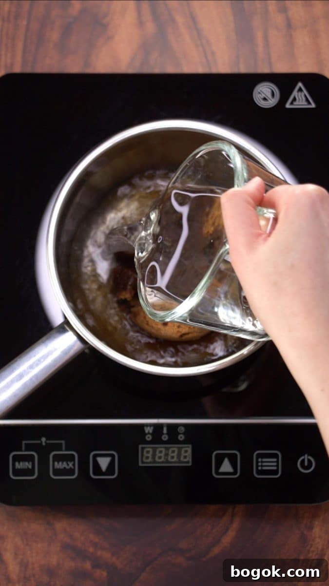 Water added to a saucepan holding brown sugar and karo syrup - Hostess At Heart