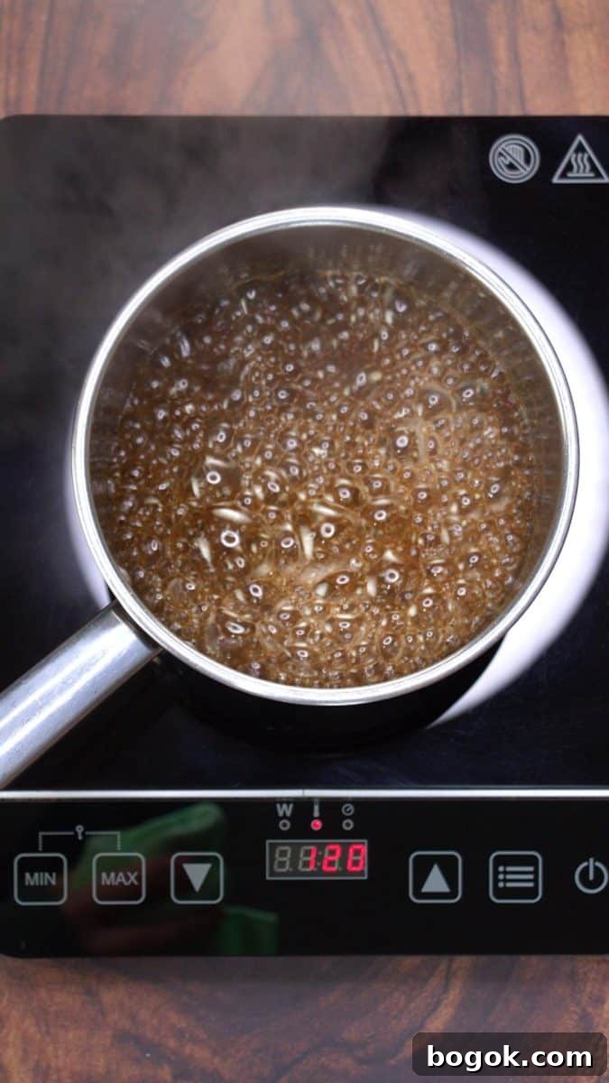A saucepan filled with a bubbling brown sugar simple syrup mixture. Hostess At Heart