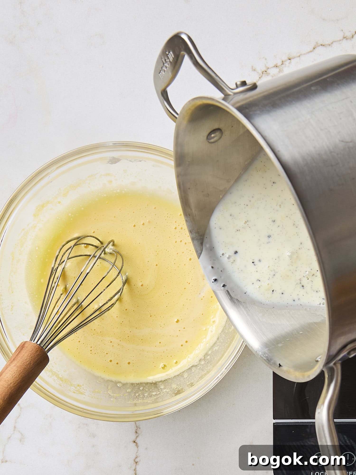 Tempering egg yolk mixture into milk mixture for pastry cream.