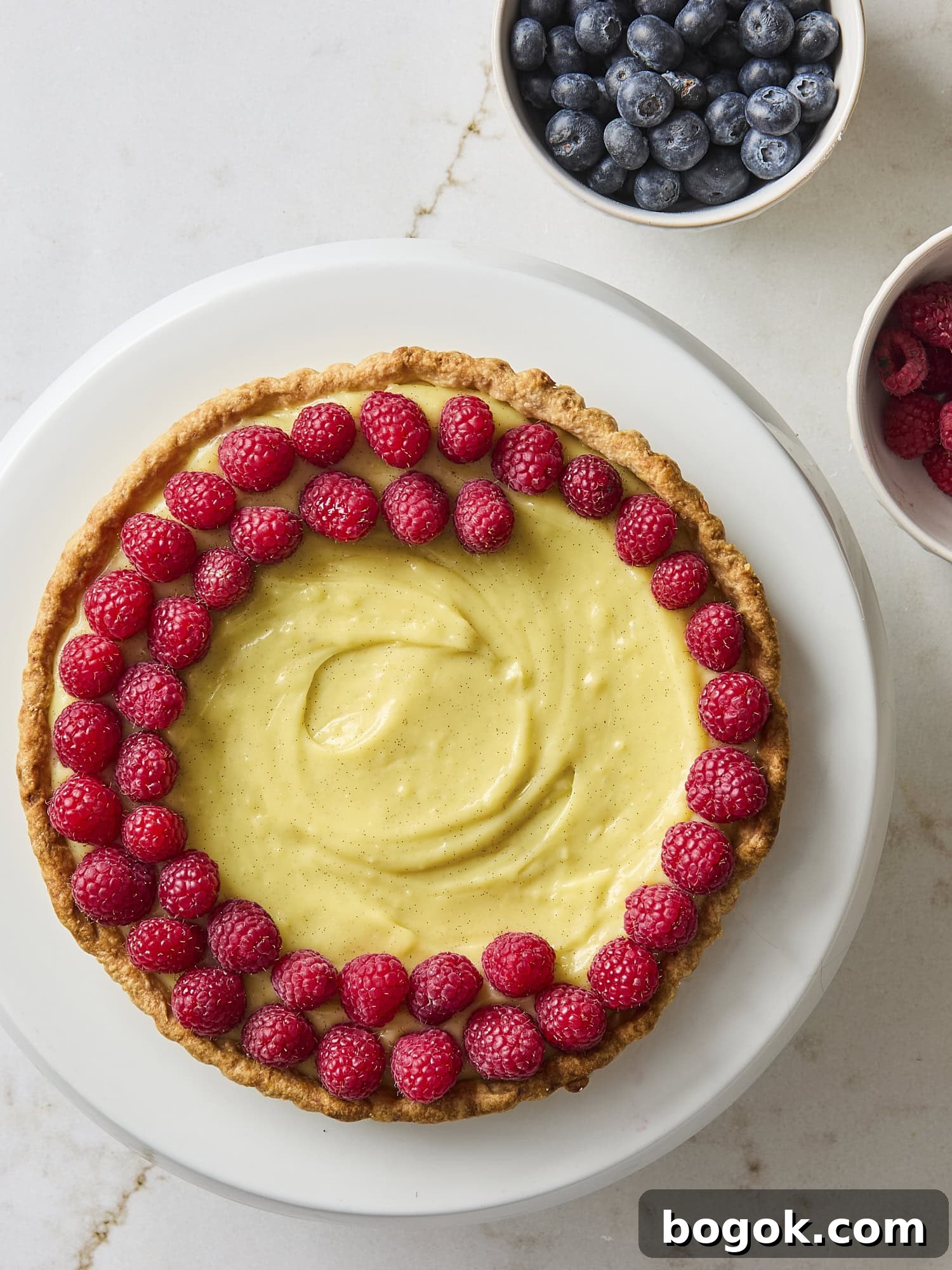 Assembly of a fruit tart with raspberries.