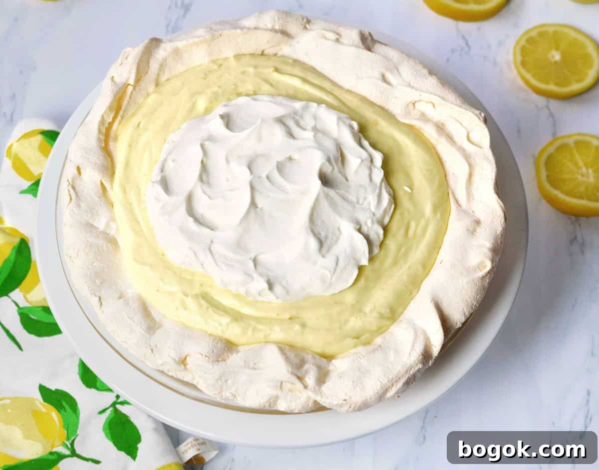 Light and Fluffy Lemon Angel Pie Recipe 11 Full lemon angel pie on white platter.
