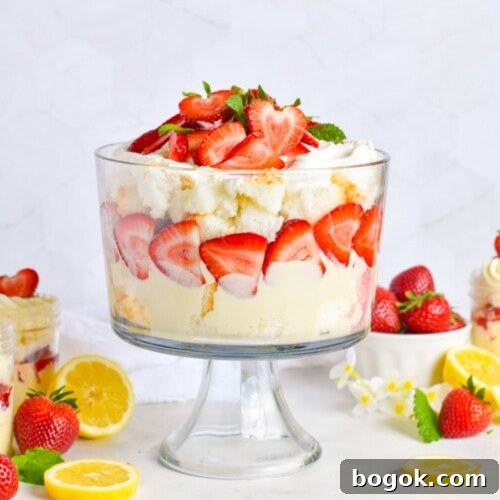 strawberry trifle layered with lemon mousse and angel food cake in glass trifle bowl.