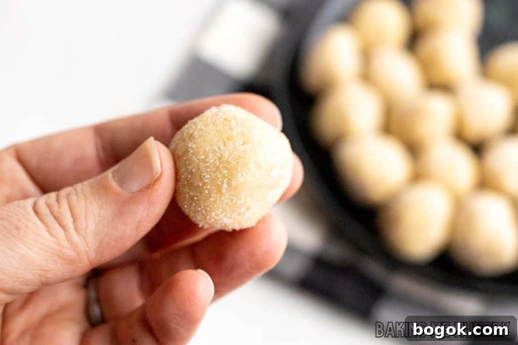 Safe-to-Eat Sugar Cookie Dough Recipe 10 hand holding one of the edible sugar cookie dough bites