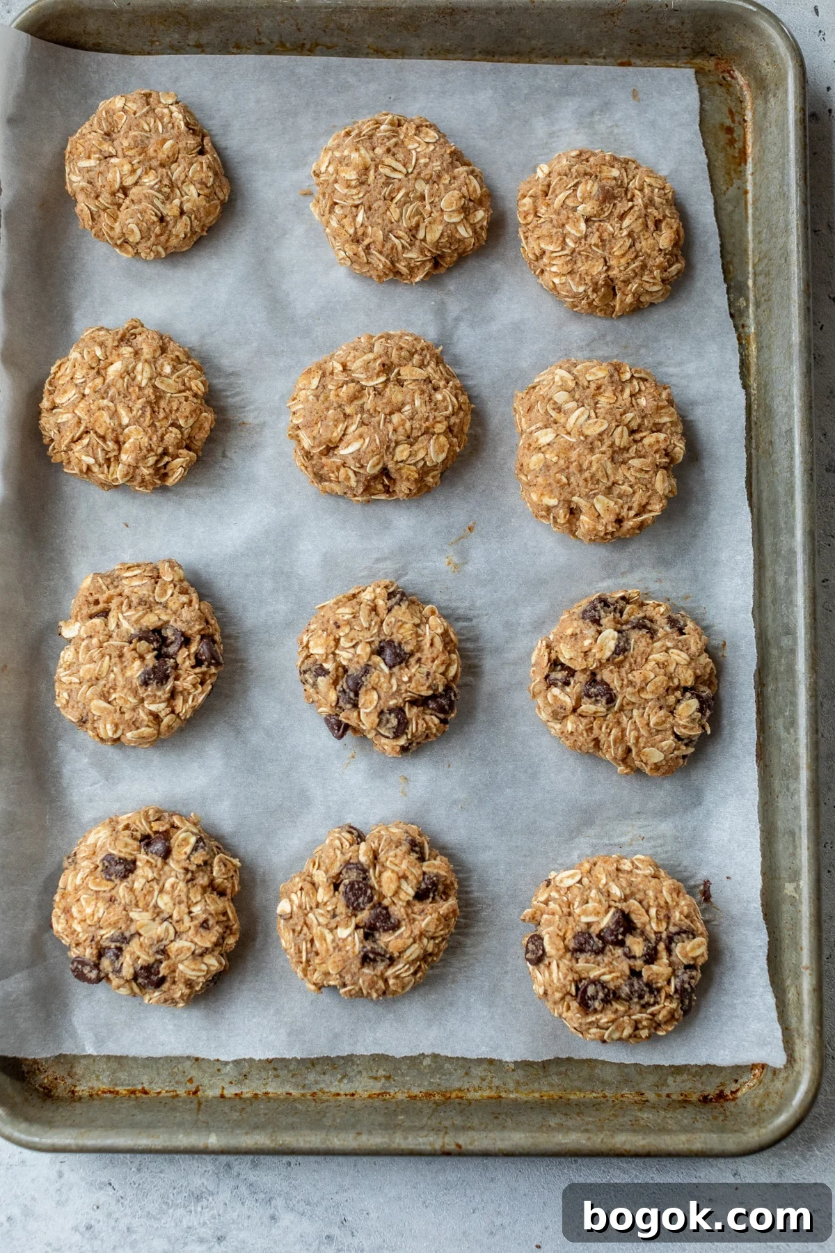 Soft and Chewy Applesauce Cookie Recipe 4 applesauce cookies on a parchment paper lined baking sheet