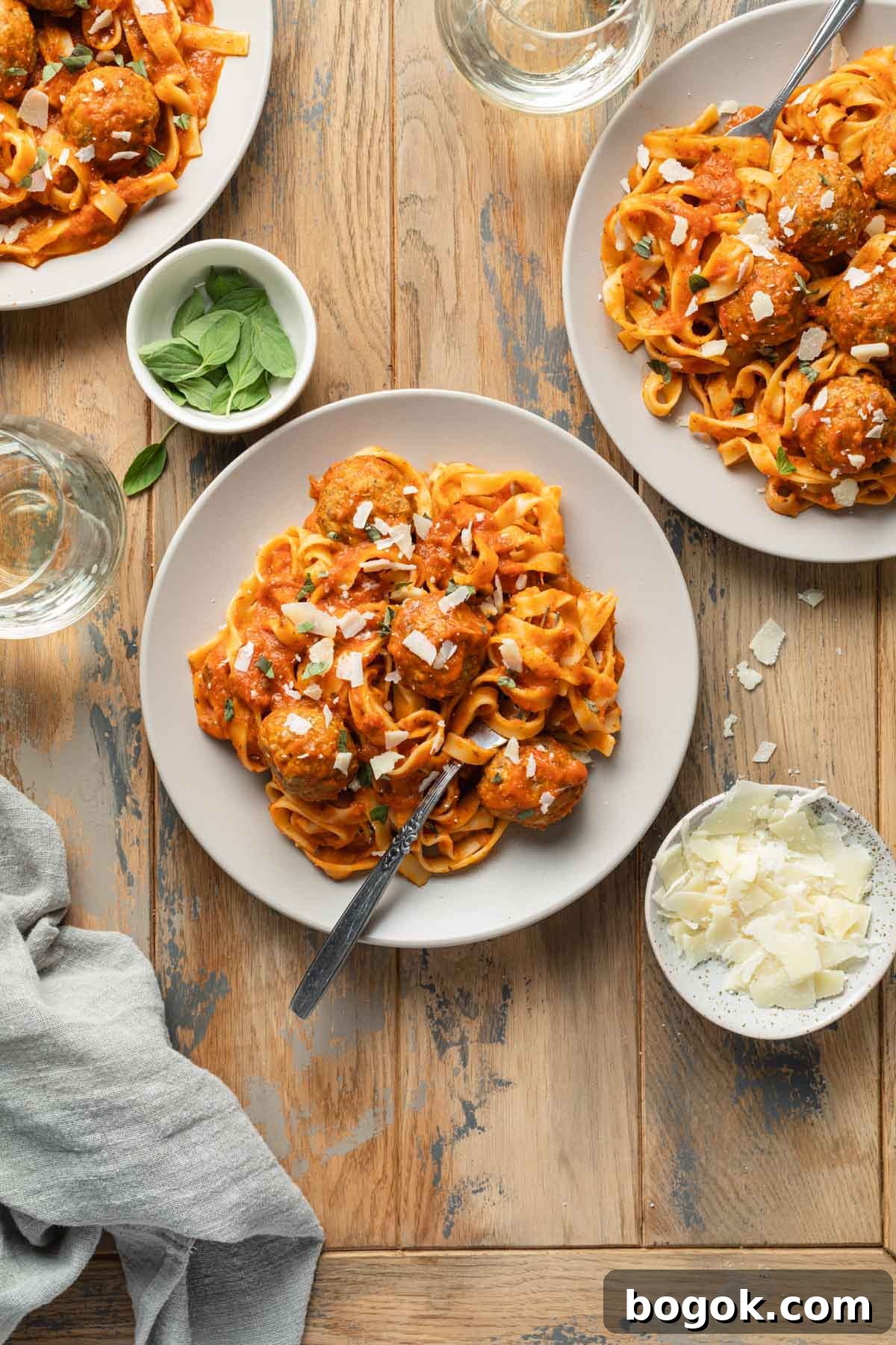 Crispy Air Fryer Turkey Meatballs with Garlic Herb Sauce 2 Overhead view of plates of pasta and turkey meatballs.