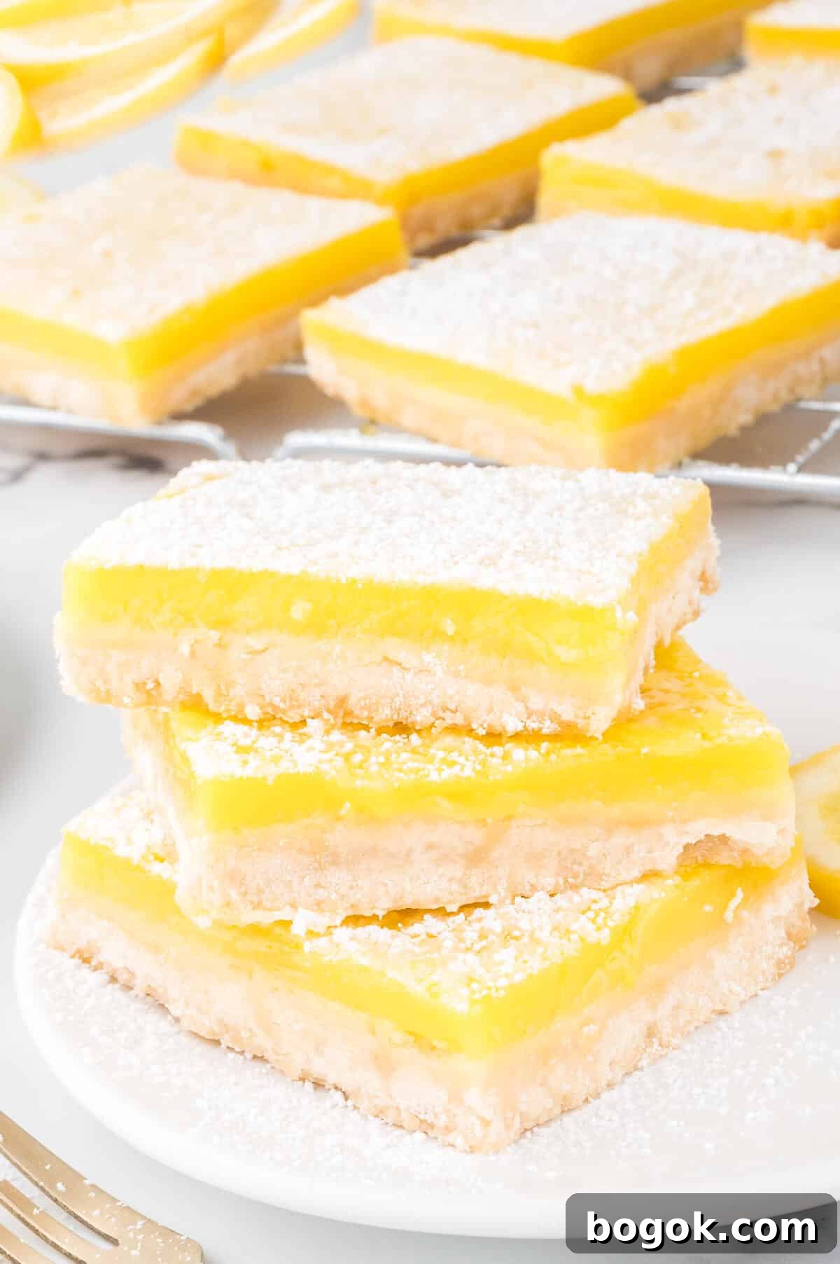 Classic Lemon Bars with Buttery Shortbread Crust 5 A stack of the recipe on a plate.