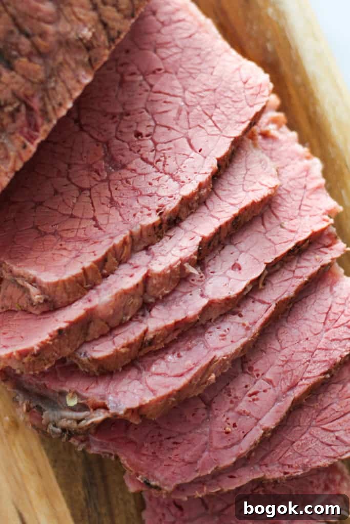 Stovetop Corned Beef: Tender, Flavorful Recipe and Tips 6 slices of corned beef on a wooden serving board.