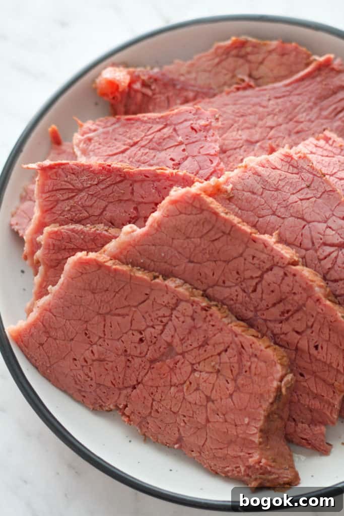 Stovetop Corned Beef: Tender, Flavorful Recipe and Tips 7 slices of corned beef on a white plate.