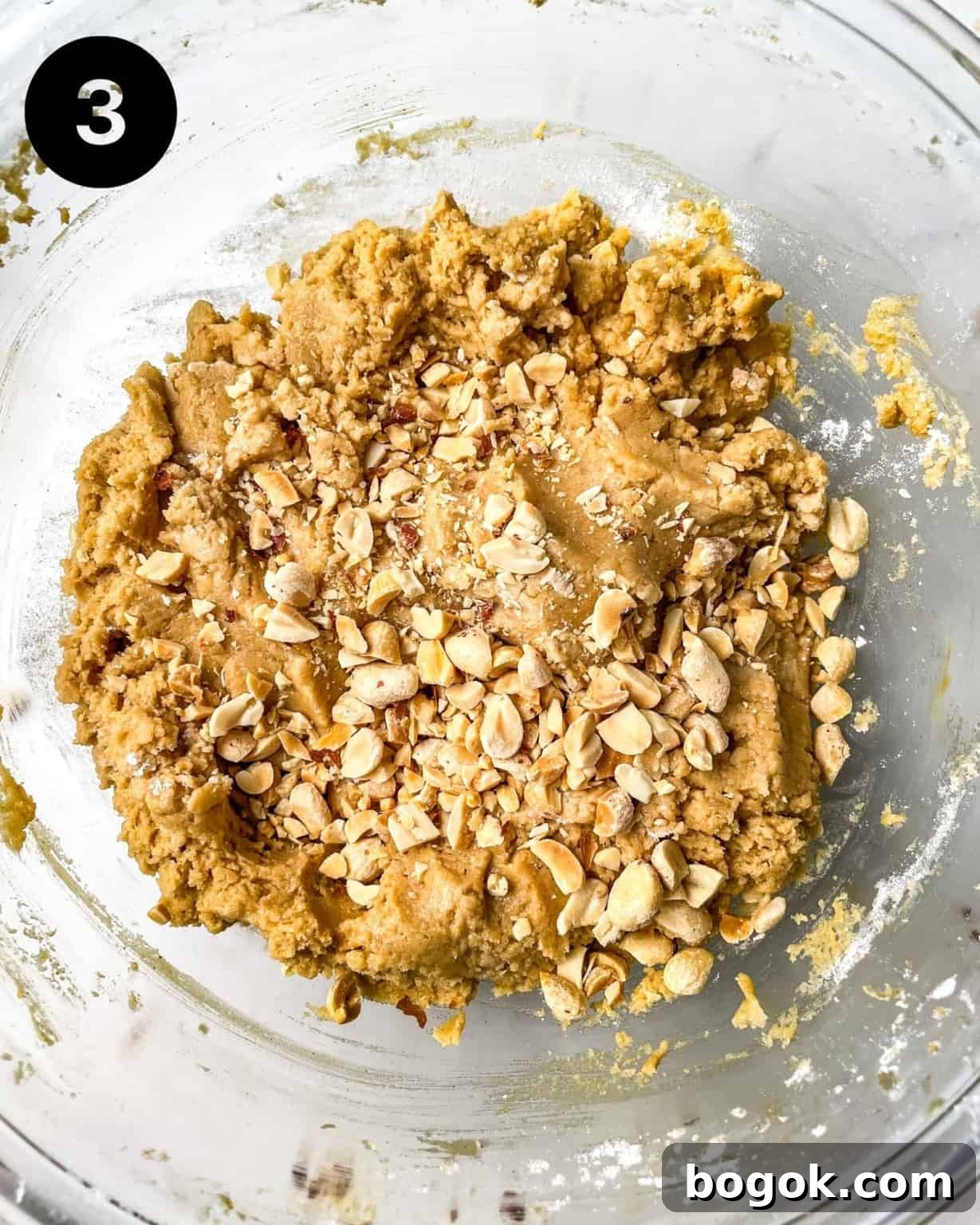 Chewy Peanut Butter Cookie Recipe for Perfect Texture 7 chewy peanut butter cookie dough in a bowl with chopped peanuts.