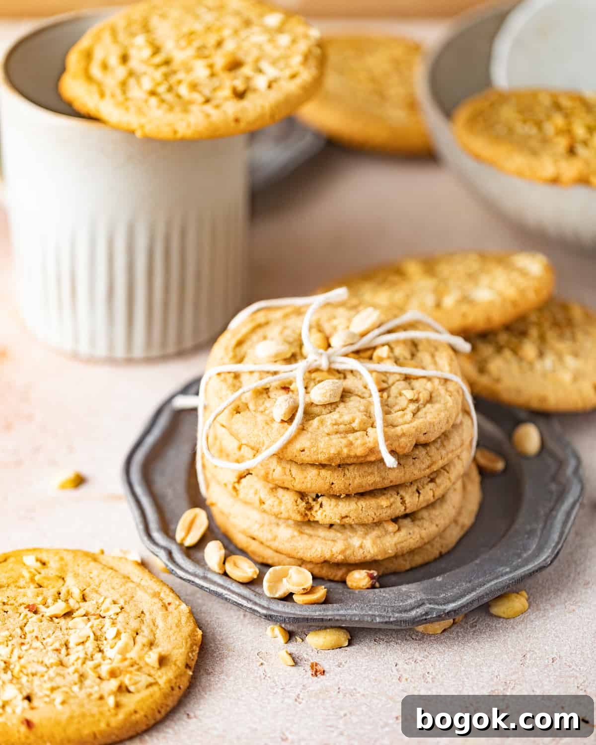 Chewy Peanut Butter Cookie Recipe for Perfect Texture 8 chewy peanut butter cookies on a silver plate wrapped with a bow.