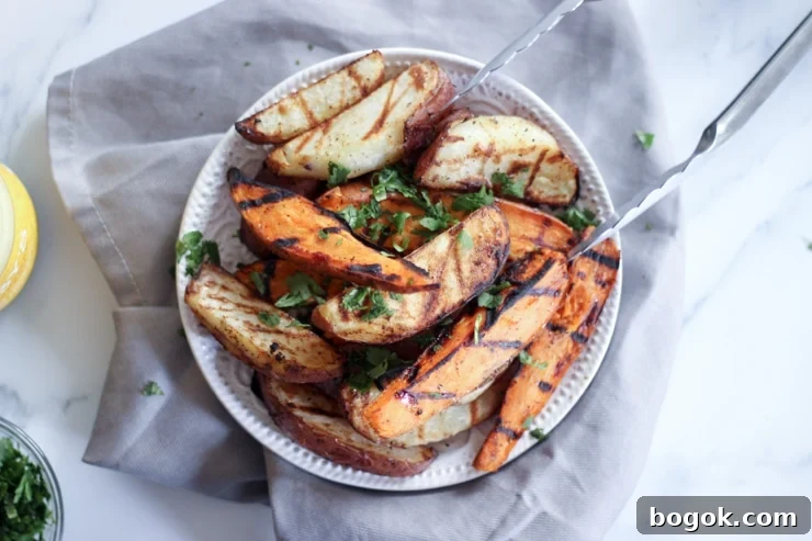 Crispy Grilled Potato Wedges with Garlic Herb Dip 2 grilled sweet potatoes on a white plate and kitchen towel