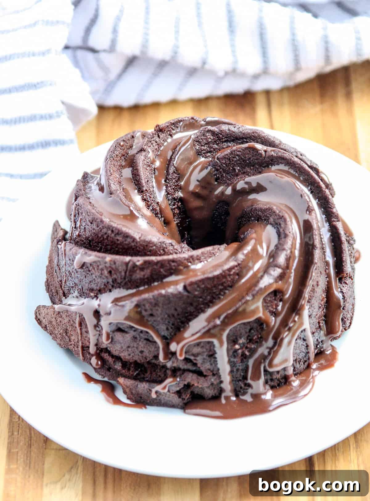 Moist Fluffy Air Fryer Cake Recipe 3 The chocolate cake on a white plate drizzled with chocolate sauce.