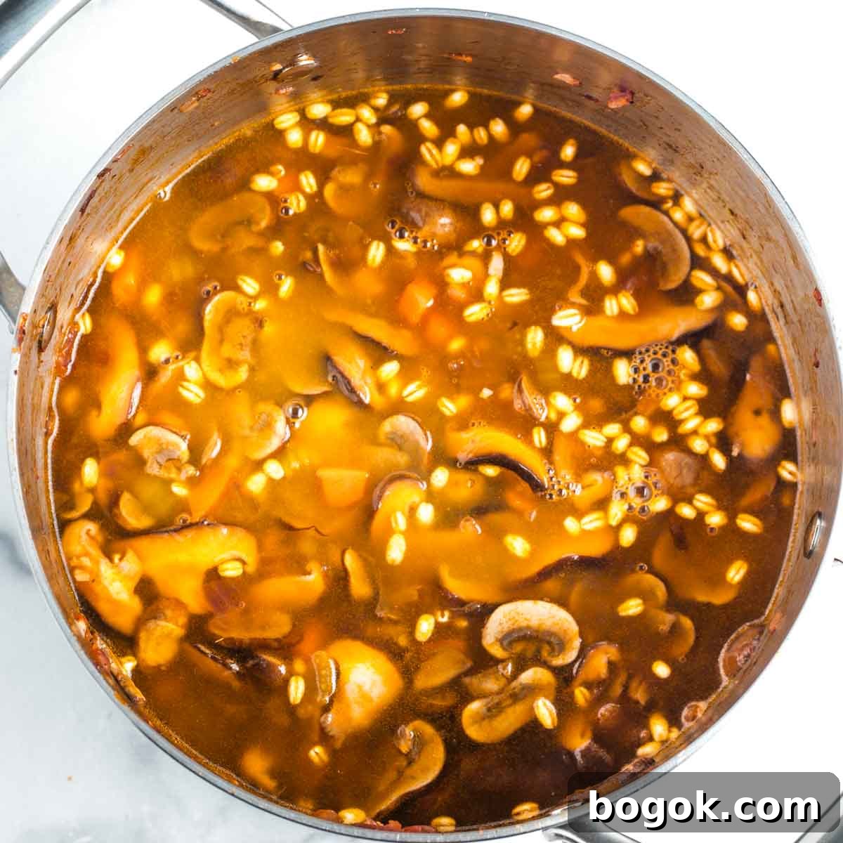 Hearty Vegan Miso Mushroom and Barley Soup Recipe 13 Mushroom barley soup, cooking in a pot.