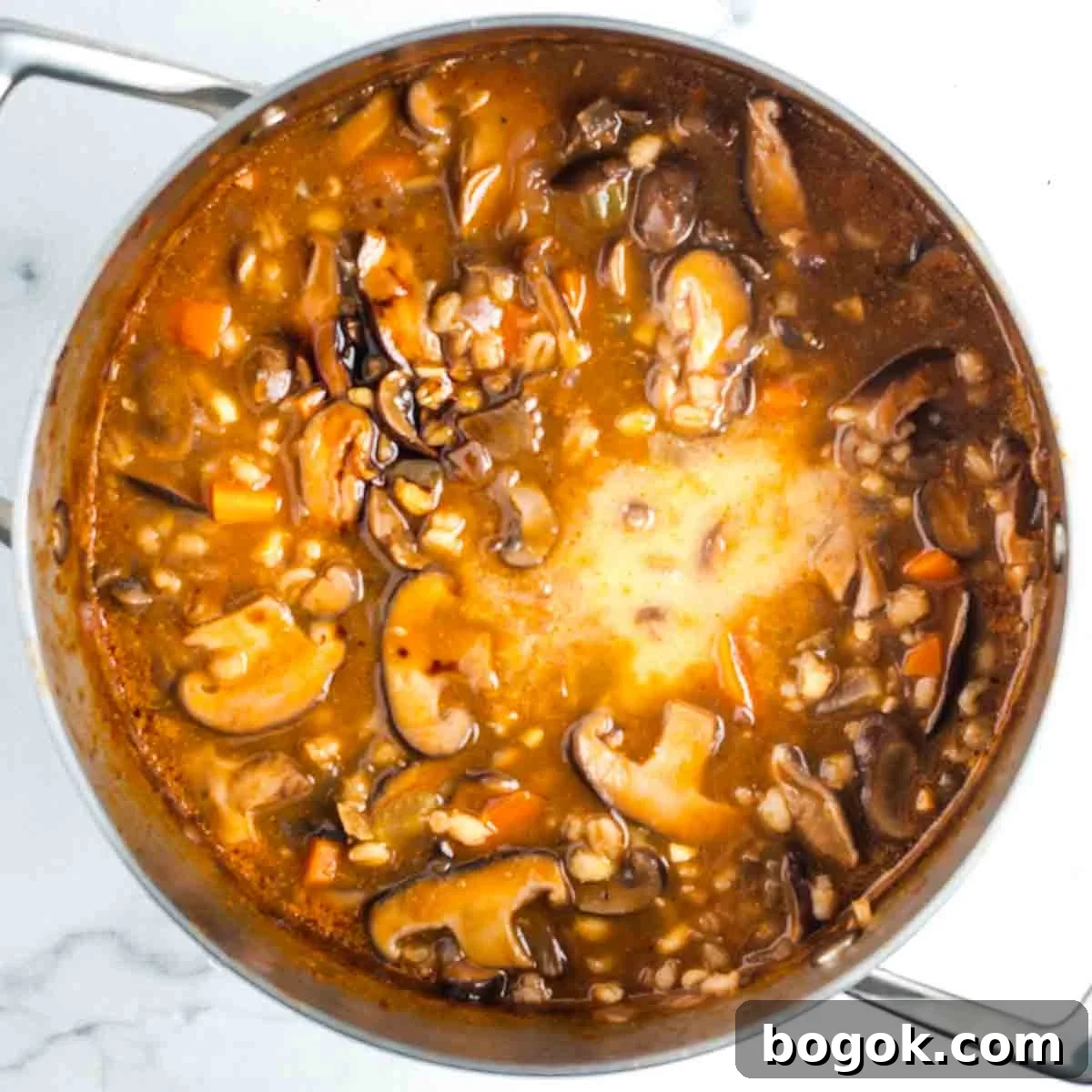 Hearty Vegan Miso Mushroom and Barley Soup Recipe 14 White slurry ina pot of mushroom barley soup.