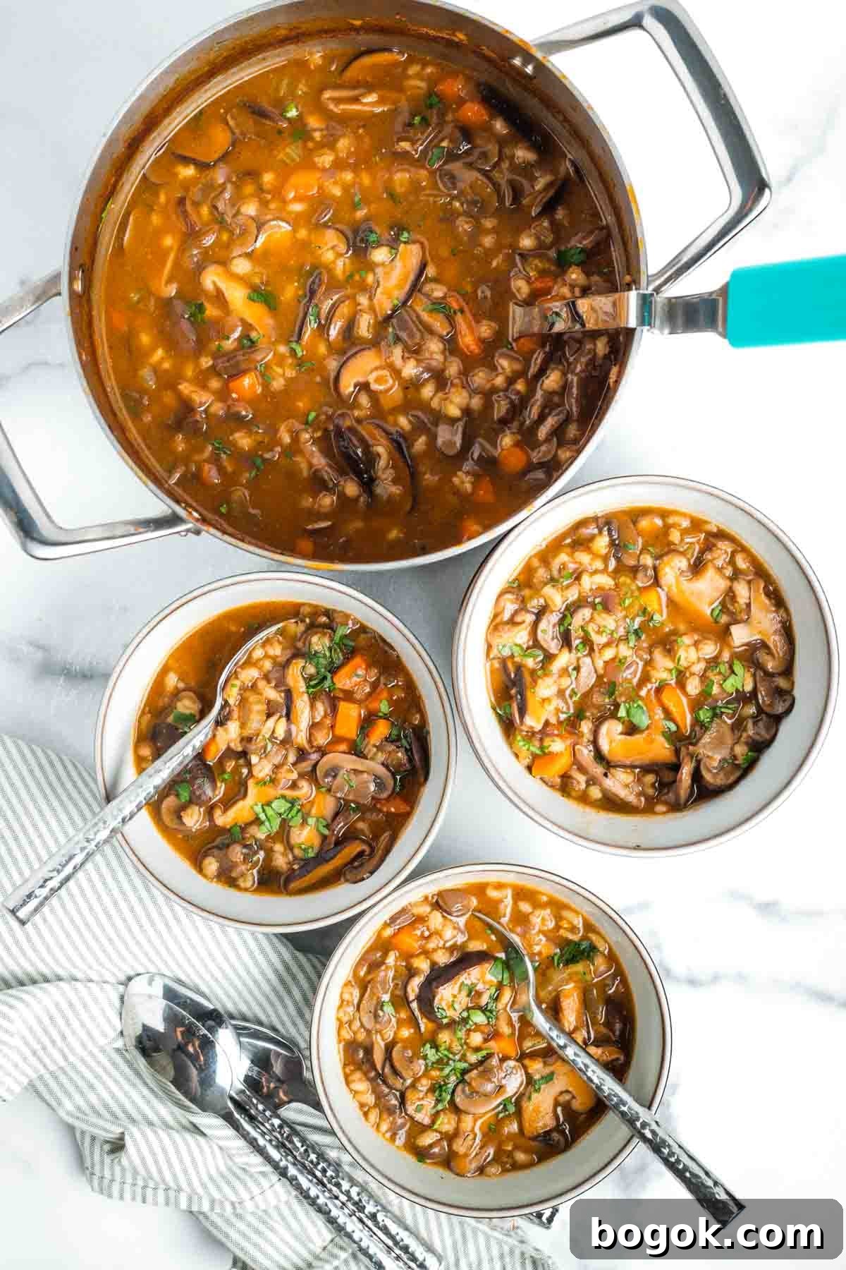 Hearty Vegan Miso Mushroom and Barley Soup Recipe 17 Three bowls of chunky mushroom barley soup and a pot full with ladle.