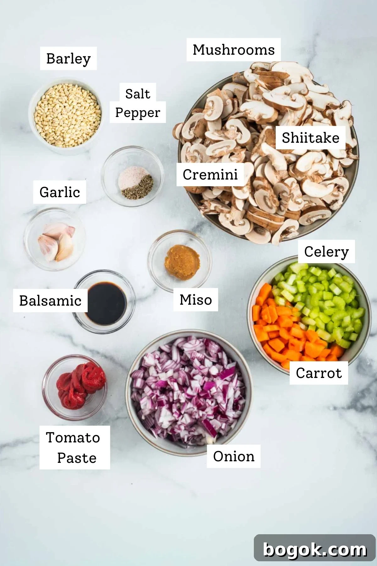 Hearty Vegan Miso Mushroom and Barley Soup Recipe 4 Labeled ingredients: sliced mushrooms, barley, salt and pepper, garlic cloves, chopped onion, celery and carrots, tomato paste, balsamic vinegar, miso paste.