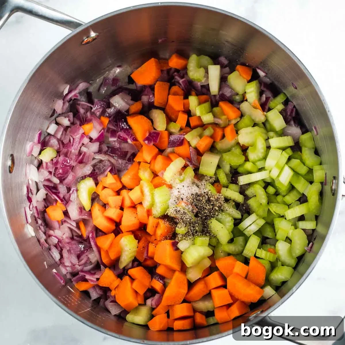 Hearty Vegan Miso Mushroom and Barley Soup Recipe 7 Soup pot with diced red onion, celery and carrot, plus salt and pepper.